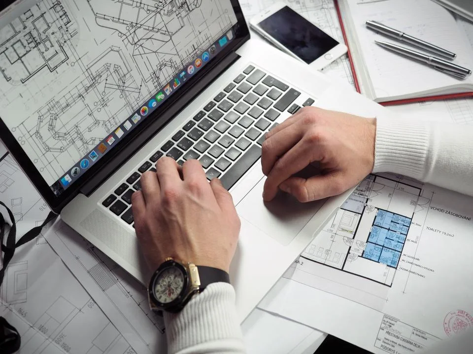 Haven Real Estate property platform on a laptop beside floor plans