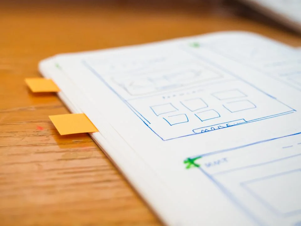 Hand-drawn UI wireframes in a notebook